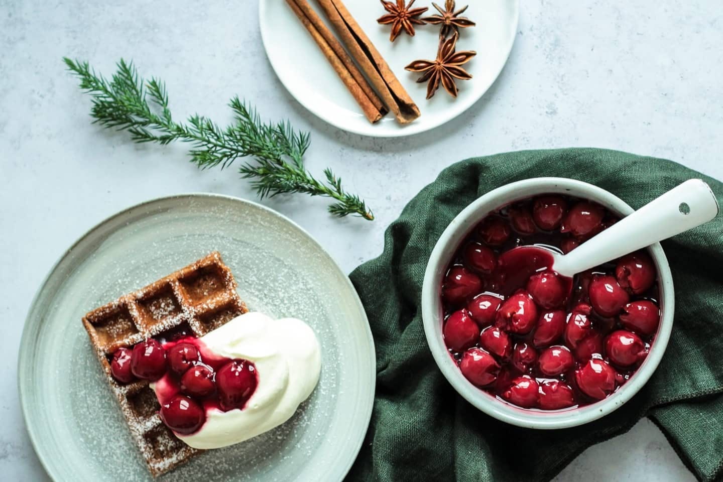 Waffel auf einem Teller mit Schlagobers und Kirschen