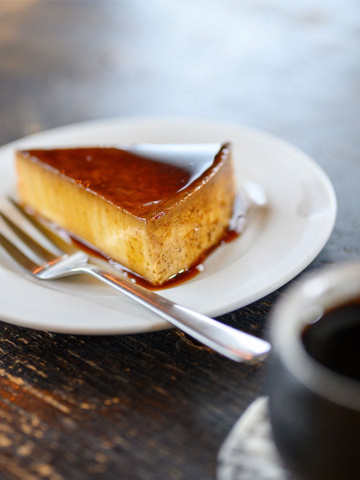 A piece of caramel cake on a white plate.